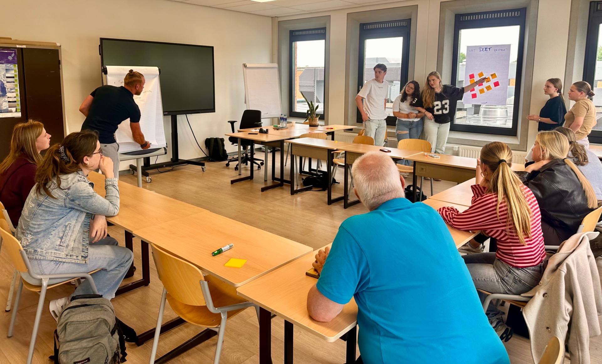 Leerlingen presenteren en werken met post-its tijdens een interactieve workshop van ImpactWijs.