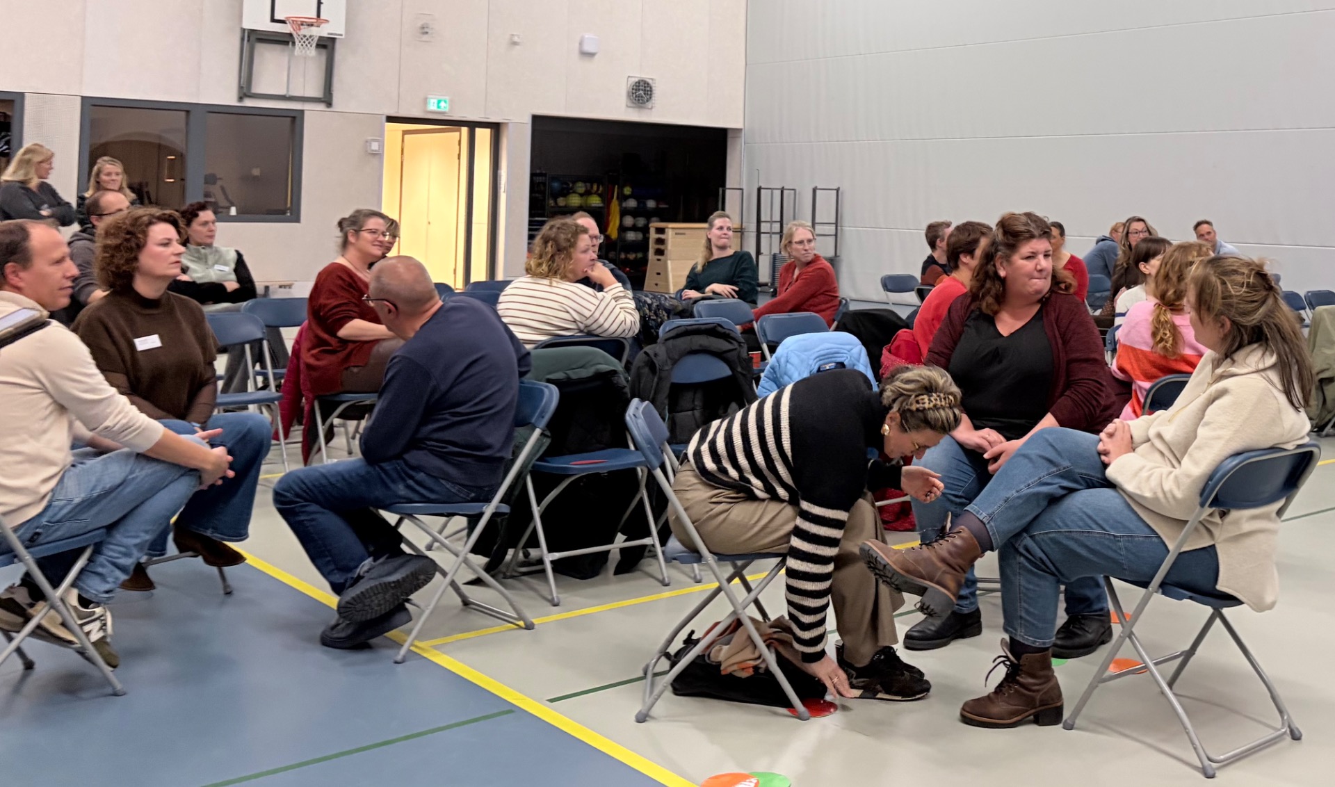 Ouders wisselen ervaringen uit tijdens een interactieve ouderavond van ImpactWijs.
